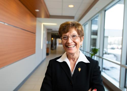 A woman smiles for a photo in a hallway