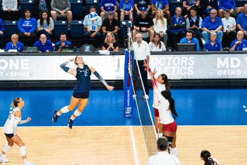 A volleyball player jumps to hit a ball