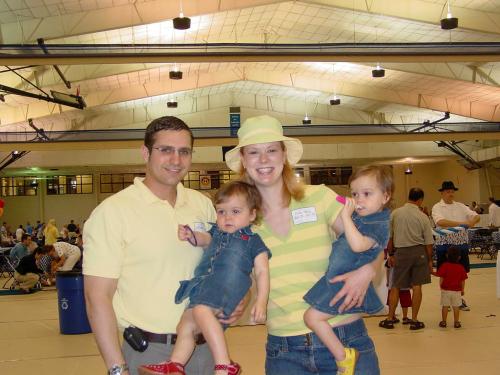 A family stands together in a gym