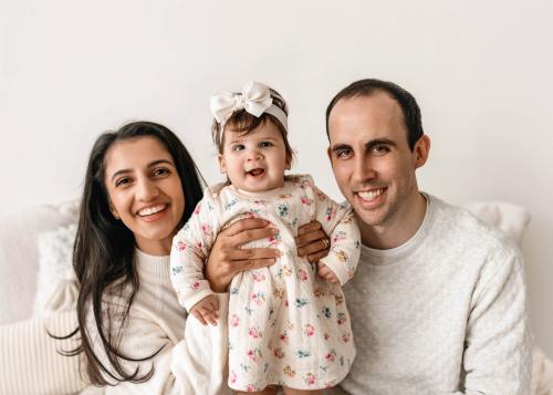 A couple smiles with their child
