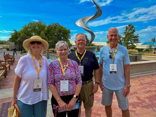 Four alumni pose for a photo together