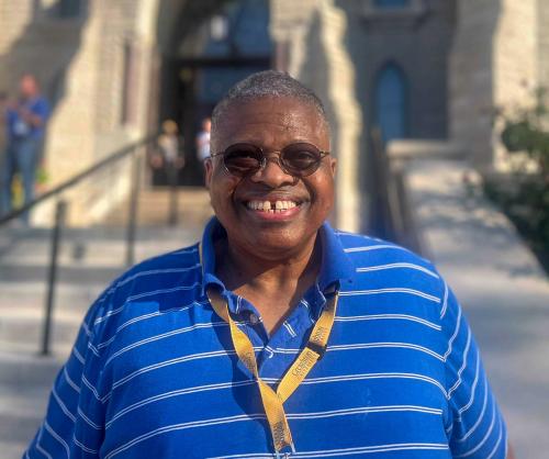 A man smiling in front of a church