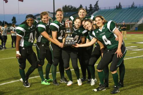 A women's football team poses with a trophy