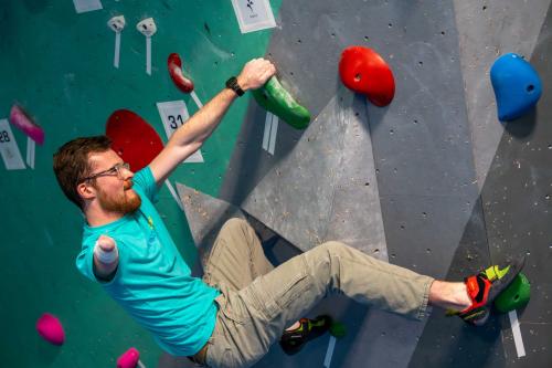An adaptive climber moves up a rock wall