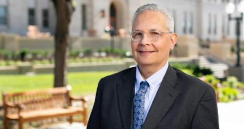 A man in a suit smiles