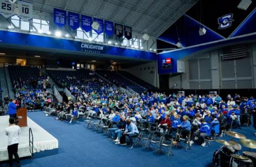 Fans join a basketball team to watch a tournament selection show