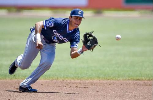 A baseball player fields the ball