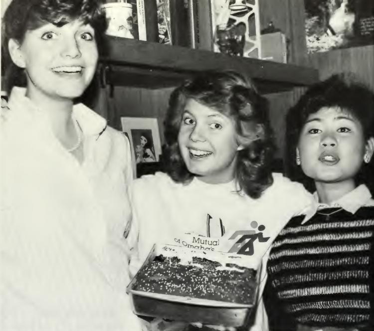 Three students celebrating a birthday pose for a picture in 1986