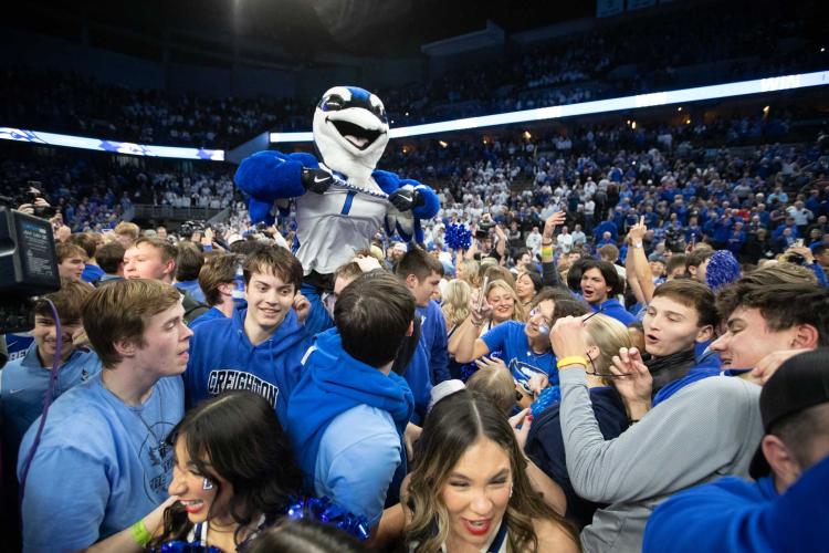 A mascot rises above the crowd during a court storm