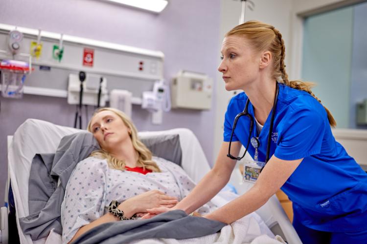 A nursing student helps a patient.