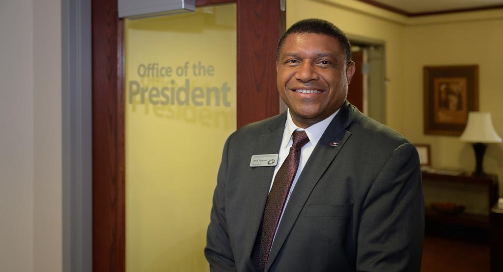 A photo of Ron Patterson smiling outside his office