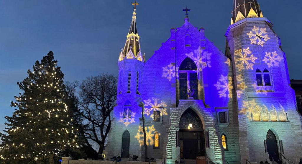 Blue and white festive spotlights shine on St. John's Church