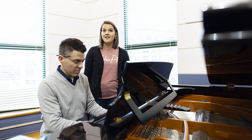 Maggie Brueck sings at a piano.