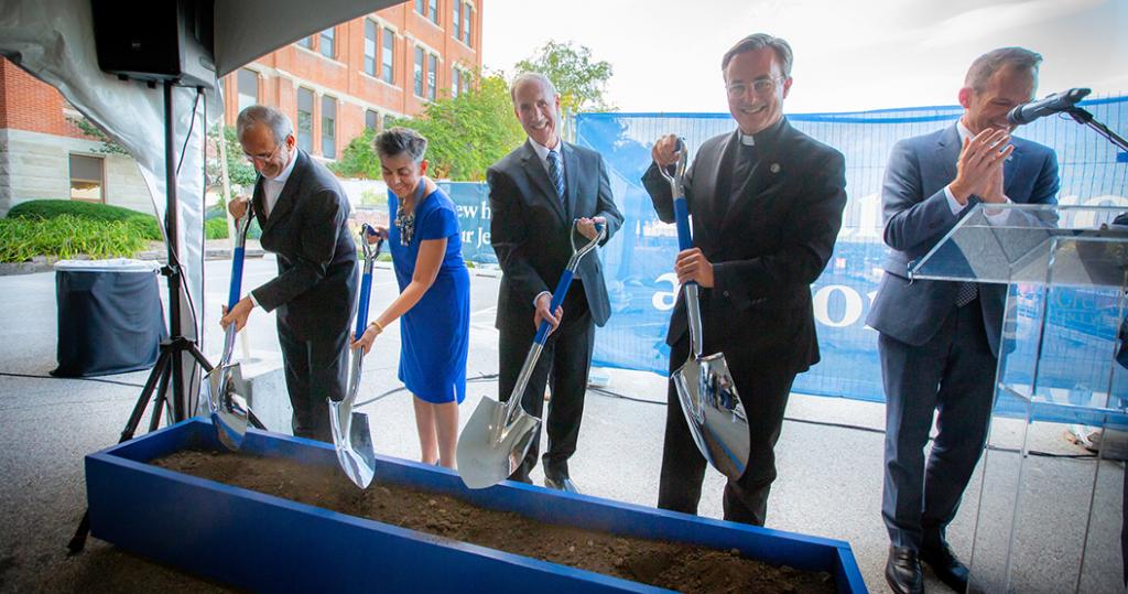 Donors and university leaders shovel dirt at the Jesuit Residence ceremonial groundbreaking.