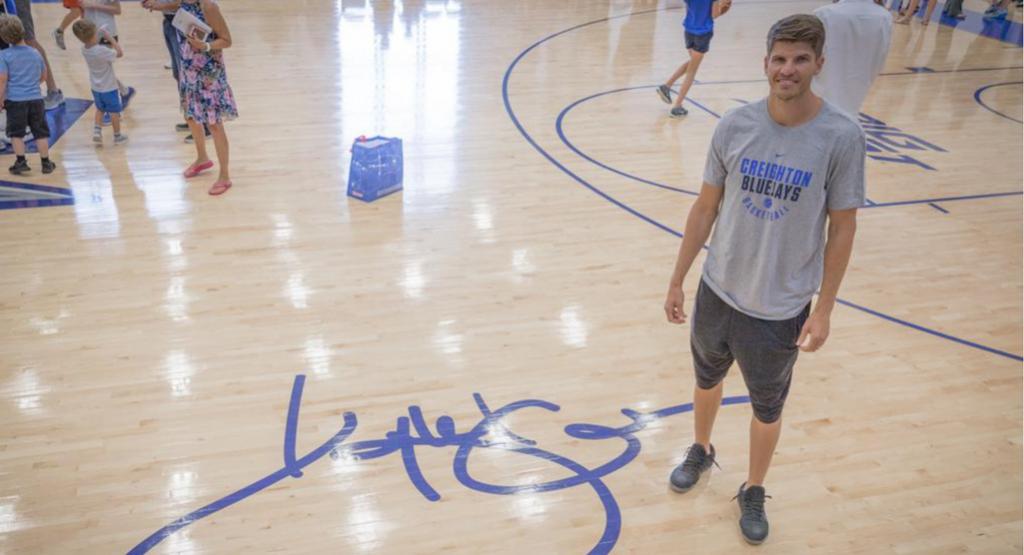 Kyle Korver stands next to his signature on the courts inside the McDermott Center practice facility