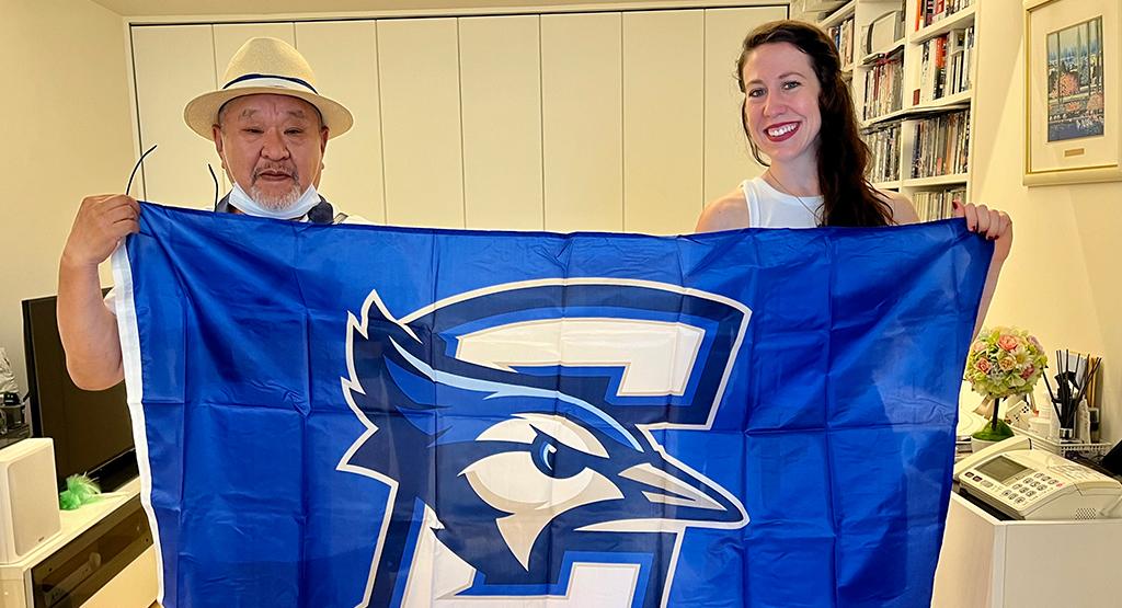 Takanori Korematsu and Lucy Hancock pose with the Creighton flag.