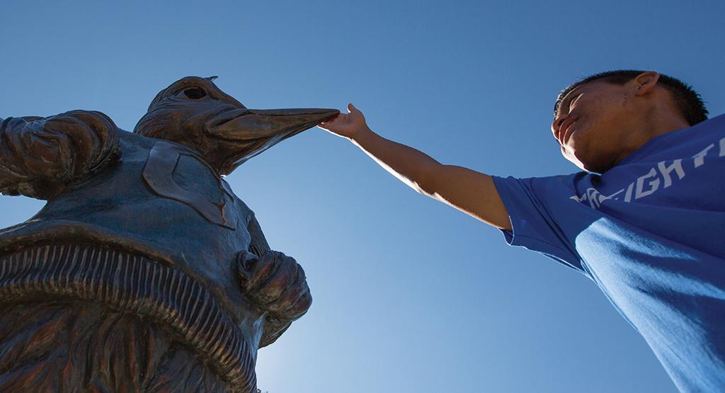 Student taps Billy Bluejay's beak