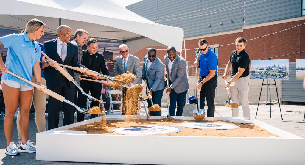 Group of people lifts up dirt with shovels