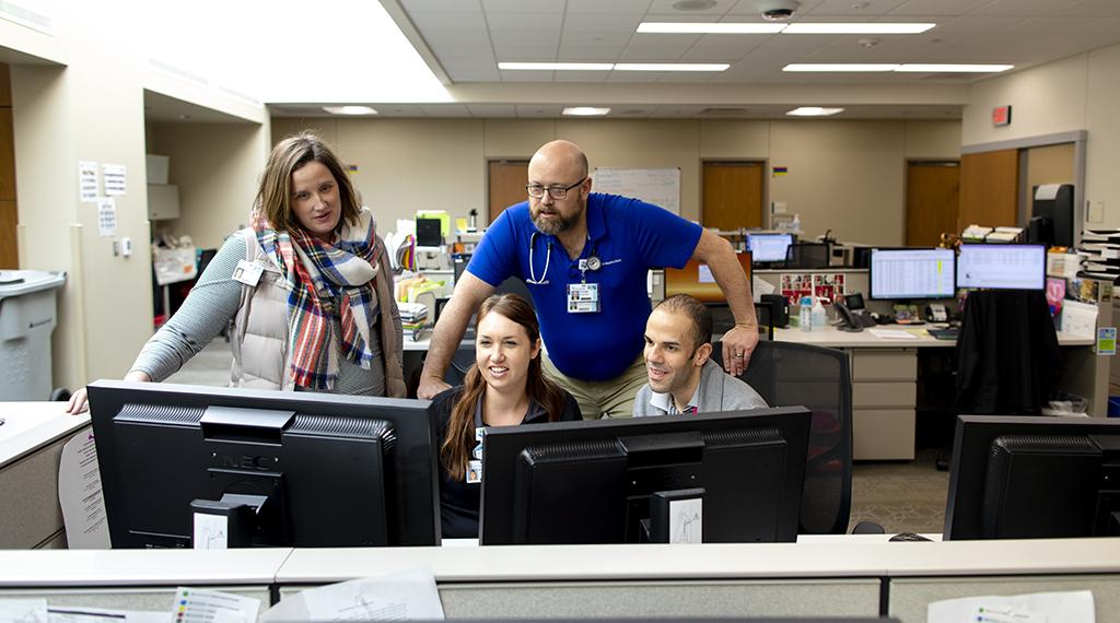 Clinicians work together around a computer.