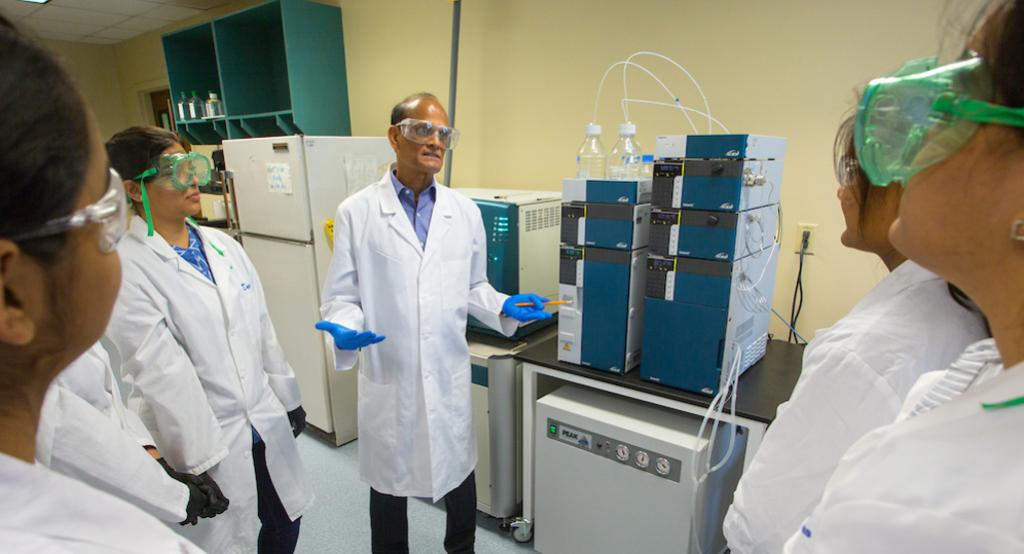 Alekha Dash speaks with students in his lab.