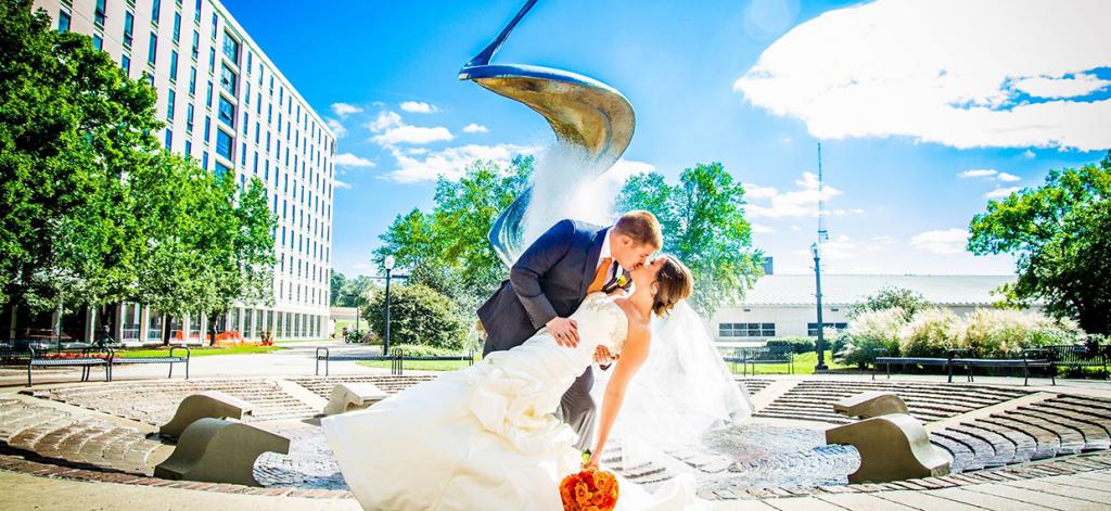 Carrie, OTD'12, BSHS'12, and Spencer Werth, BA'11, MS'14, JD'14, marriage photo in front of fountain