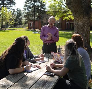 Staff member talks to students in the Jesuit Gardens