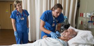 Two nurses treat a patient.