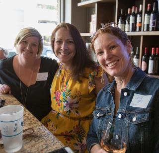 three women sitting together and smiling during Creighton University reunion