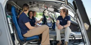 EMS students talking while sitting in a landed helicopter.