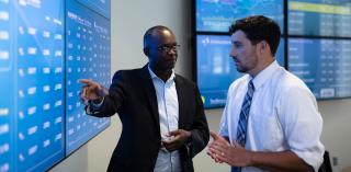 A student and faculty member talk in the Heider College of Business.