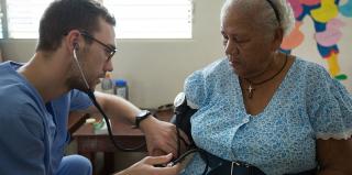 A student physician examines a patient.