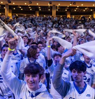 Creighton fans wave towels and cheer at a basketball game