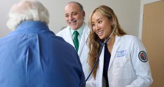 A student and faculty physician treat a patient.