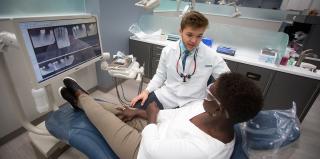 A Creighton dental student talks with a patient in the dental clinic