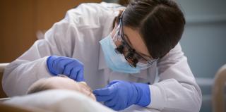 Creighton dental student inspects the mouth of a patient