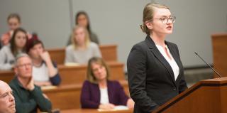 Female law student speaks to a courtroom