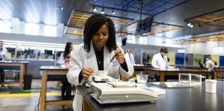 Pharmacy student does lab work in a classroom.