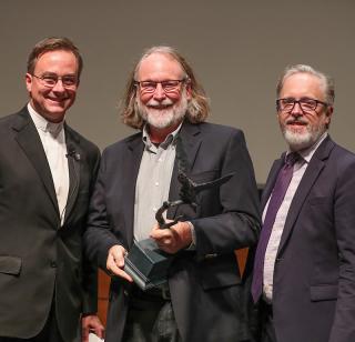 Father Hendrickson, John O'Keefe and Tracy Leavelle after O'Keefe won Creighton’s inaugural Kingfisher Award at a campus town hall.