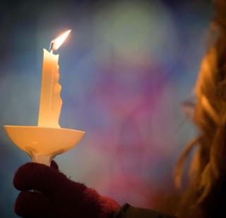 A woman holds a candle in St. John's Church.