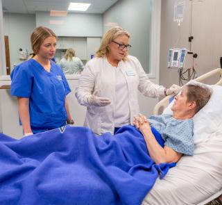 Nursing student and faculty working with patient