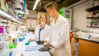 A student and professor work in the lab.