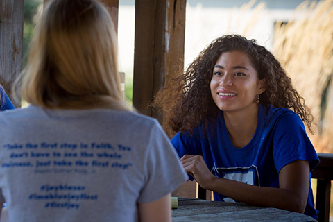 A student speaks and smiles.