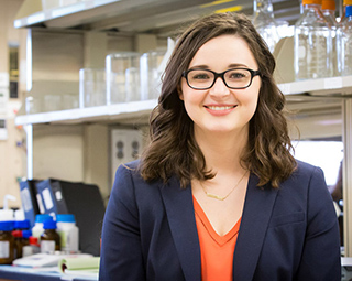 Female student smiling to the camera in a lab