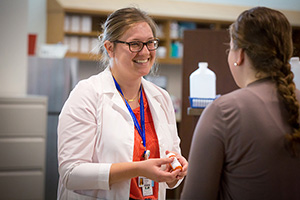 A pharmacy student speaks with a patient.