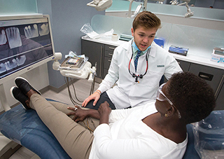 Creighton dental student talks with a patient in a clinic setting
